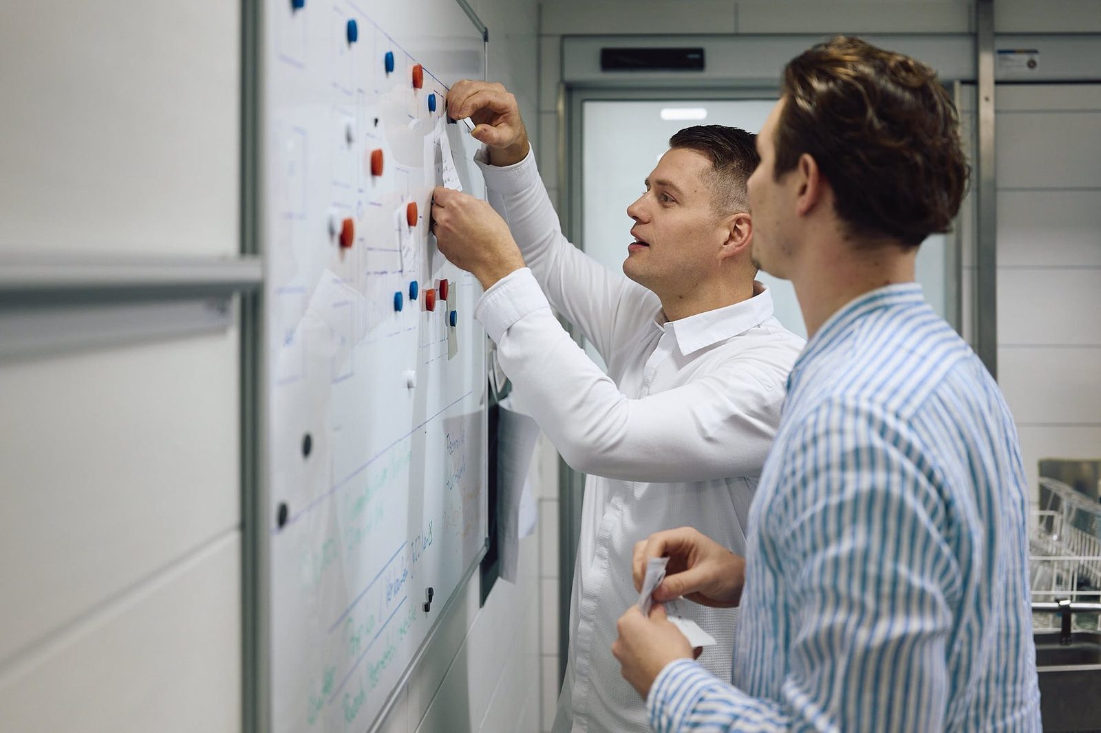 Cornelius Speinle plant Abläufe mit einem Kunden am Whiteboard