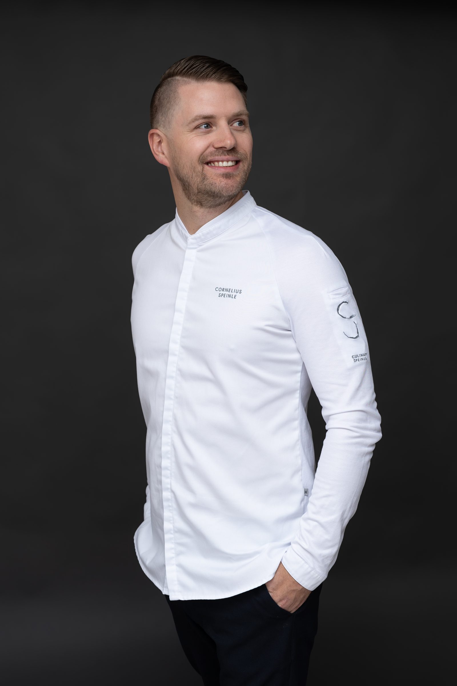 Cornelius Speinle in weißer Kochjacke mit Culinary-Speinle-Stickerei